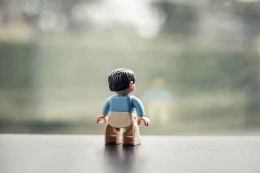 Een Lego-poppetje alleen, van achteren gezien