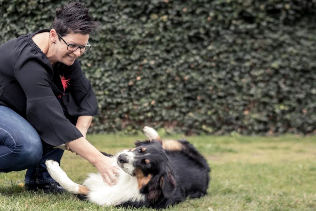Daniella Wellens buiten, spelend met een Berner Sennenhond